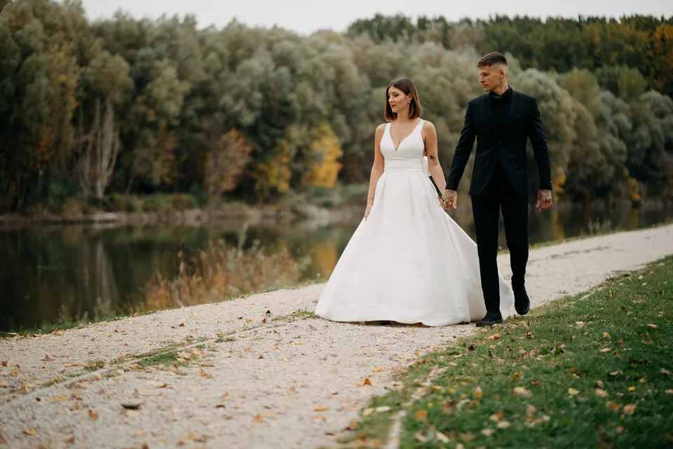 Rebeka és Martin: Kéz a kézben a vízparti kavicsos sétányon.