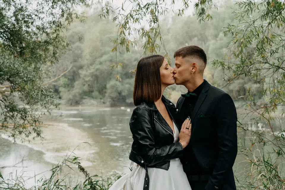 Rebeka és Martin: Esküvői csók a lehajló zöld ágak alatt.