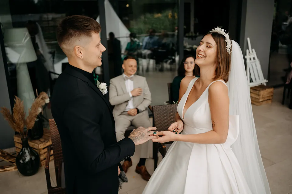 Rebeka és Martin: A pár kézen fogva áll a szertartáson.